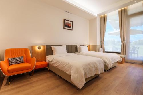 員山郷にある優勝美地民宿二館のベッドルーム1室(ベッド2台、オレンジの椅子付)