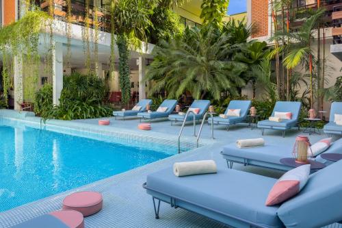 a hotel swimming pool with lounge chairs next to a building at Viroth's Villa in Siem Reap