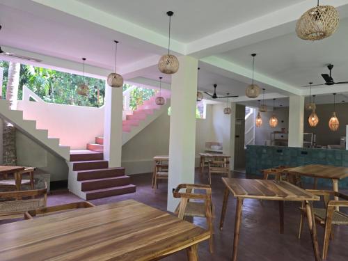 een restaurant met houten tafels en een trap bij Bunky Monkey by Monara in Hikkaduwa