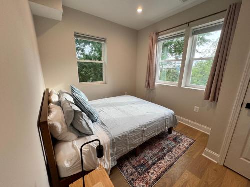 een slaapkamer met een bed en twee ramen bij Villa del Encanto in Washington