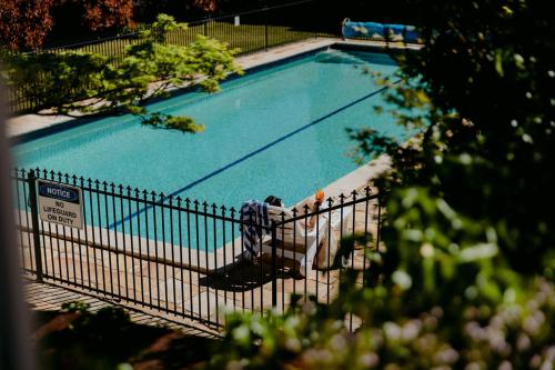 - une vue sur la piscine située derrière une clôture dans l'établissement Mountain Heritage Hotel, à Katoomba
