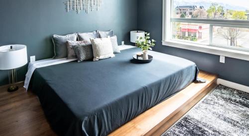 Un dormitorio con una cama grande con una planta. en Spacious New Condo in Downtown SLC, en Garden Towers Condominium