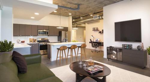 Una sala de estar con un sofá y una mesa y una cocina. en Spacious New Condo in Downtown SLC, en Garden Towers Condominium