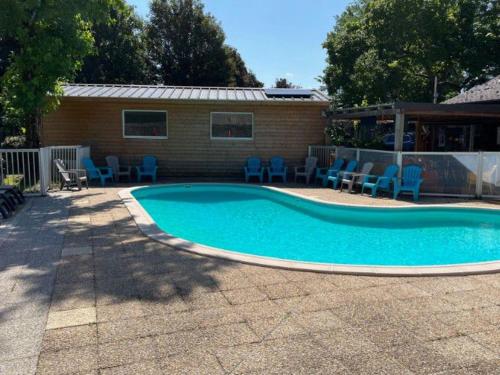 a swimming pool in a yard with chairs and a building at Mobil home avec terrasse à Gurmençon - API-1-52-612 in Gurmençon