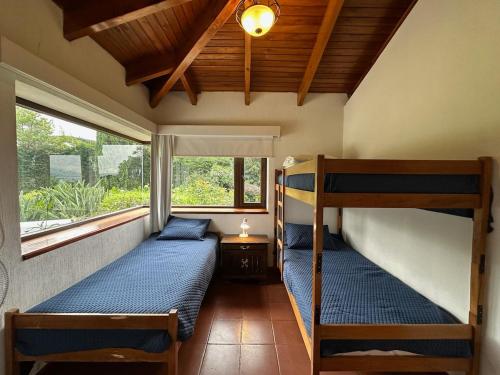 Dos literas en una habitación con ventana. en Casa Belen Panajachel, en Panajachel