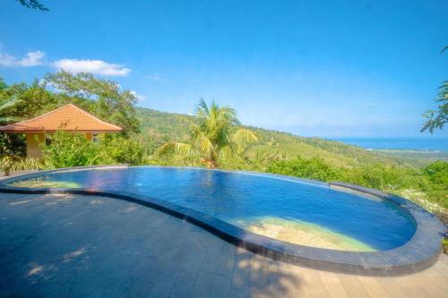 a swimming pool with a view of the ocean at Maria Secret Villa in Lovina