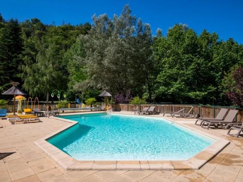 a swimming pool with chairs and trees in the background at Camping 3 étoiles - Piscine - eeed0b in Bédouès