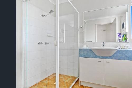 a white bathroom with a sink and a shower at Unit 15 - 45 Lorikeet Drive, Peregian Beach in Peregian Beach