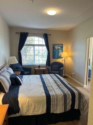 a bedroom with a bed and a chair and a window at Lagoon View and Ocean Breeze in Oceano
