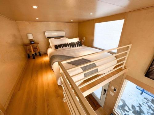 グランドジャンクショ​​ンにあるSecluded Tiny House Oasis in Grand Junction Perfect for Experiencing Nature in Comfortの小さな部屋の中に大型ベッド付きのベッドルーム1室が備わります。