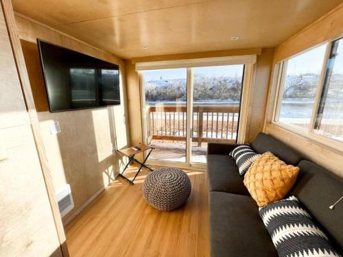グランドジャンクショ​​ンにあるSecluded Tiny House Oasis in Grand Junction Perfect for Experiencing Nature in Comfortのソファと薄型テレビのあるリビングルーム