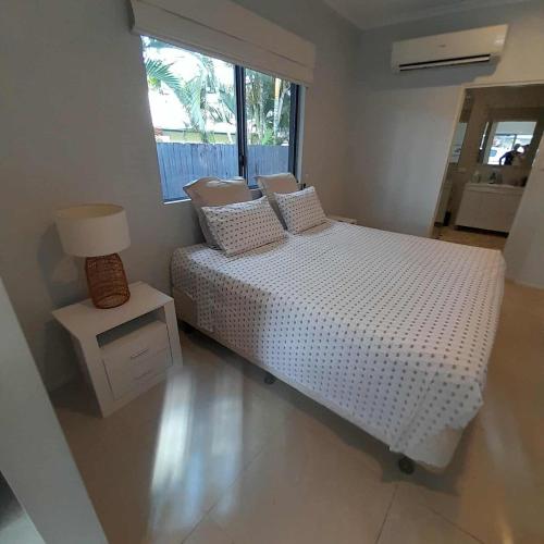 a bedroom with a white bed and a window at Reid's Retreat - Studio Apartment in Port Douglas