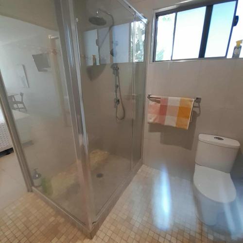 a bathroom with a shower and a toilet at Reid's Retreat - Studio Apartment in Port Douglas