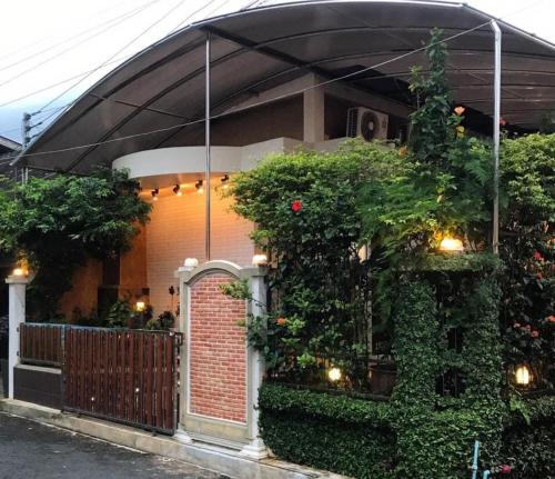 een huis met een bakstenen poort en klimop bij Rimklong boutique hotel trad in Trat