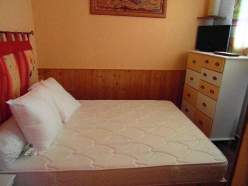 普拉茲德里斯Studio cosy centre Praz de Lys, 100m des pistes - FR-1-815-26的一间小卧室,配有一张床和一个梳妆台