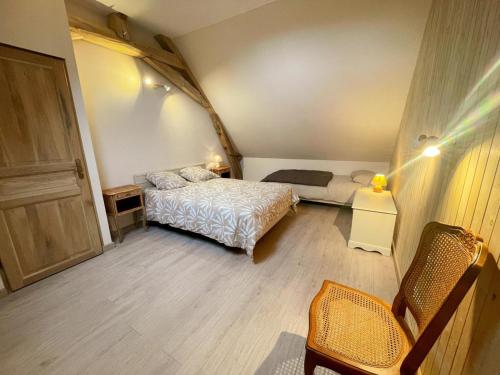 a small bedroom with a bed and a chair at Gîte à Manthelan : Confort et Charme, Jardin, Wi-Fi - FR-1-381-639 in Monfoué