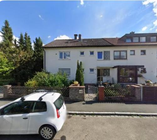une voiture blanche garée devant une maison dans l'établissement Gemütliche Wohnung für 5 Personen, Playmobil, Palm Beach, à Stein bei Nürnberg