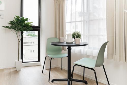 a table and chairs in a room with a window at Sunlit Canopy - A Cozy Stay in Tokyo Shinjuku Area, with Easy City Access to Shibuya in Tokyo