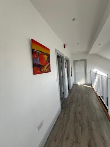 an empty hallway with a painting on a wall at BlueWillowRetreat with Sauna Spiddal in Galway
