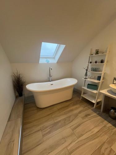 a bath tub in a bathroom with a window at BlueWillowRetreat with Sauna Spiddal in Galway