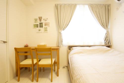 a bedroom with a bed and a table and chairs at オーブリオン恵比寿203 in Tokyo