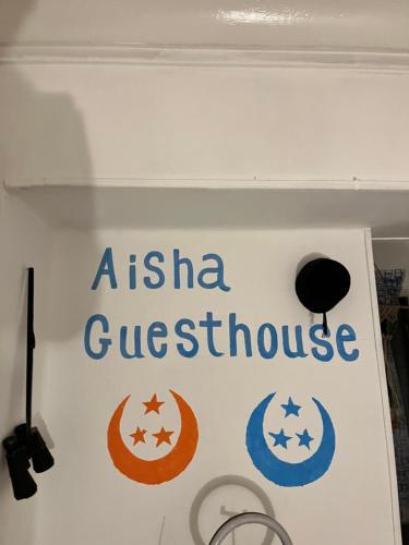 a sign for a australian guesthouse on a wall at Aisha guesthouse in Aswan