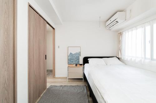 Ένα ή περισσότερα κρεβάτια σε δωμάτιο στο Sunlit Canopy - A Cozy Stay in Tokyo Shinjuku Area, with Easy City Access to Shibuya