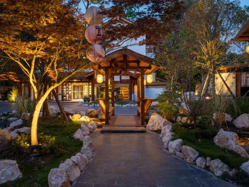 een pad dat leidt naar een gebouw met een prieel bij Chengdu Xiaoya Yard Hot Spring Hotel,Enjoy Soaking in natural hot springs,Traditional Chinese afternoon tea,Exquisite fruit platter in Longqiao