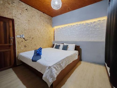 a bedroom with a bed with a blue shirt on it at บ้านหัวเรือโฮมสเตย์เกาะลิบง Baan huaruea homestay in Ko Libong