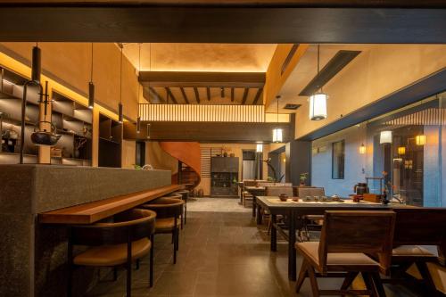 Un restaurante con barra, mesas y sillas. en Changsha Pushe Minsu, en Changsha