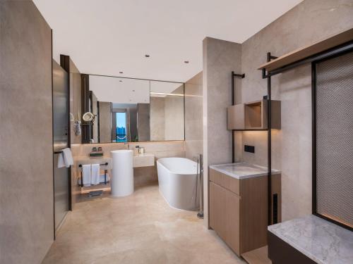 a bathroom with a tub and a sink and a mirror at Holiday Inn Beijing Daxing Centre by IHG in Beijing