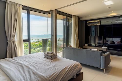 a bedroom with a bed and a large window at Seaphere Residence by Prop Hopper in Na Jomtien