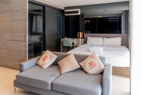 a bedroom with a bed and a couch at Seaphere Residence by Prop Hopper in Na Jomtien