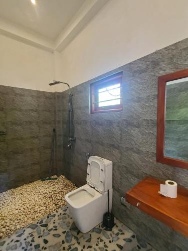 Baño con aseo en la esquina de una habitación en Charisma Apartments, en Ahangama