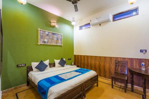 - une chambre dotée d'un lit avec un mur vert dans l'établissement Hotel The Vintage villa Jaisalmer, à Jaisalmer