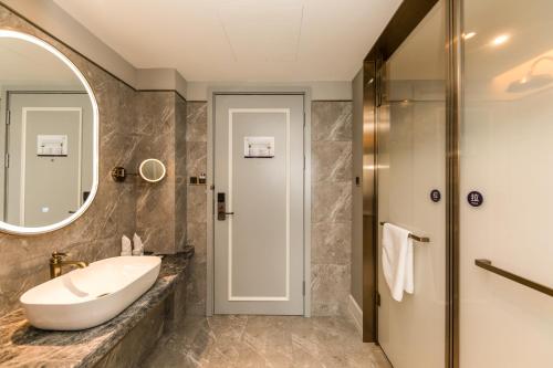 un bagno con lavandino e specchio di Mercure Xian City Centre a Xi'an
