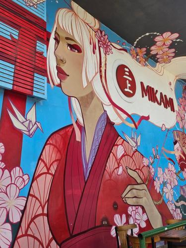 een muurschildering van een vrouw in een rode jurk op een muur bij Kit Osaka in Brasilia
