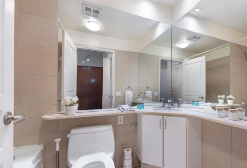 a bathroom with a toilet and a large mirror at Luxury 1-Bedroom Condo in Yorkville, Downtown Toronto in Toronto