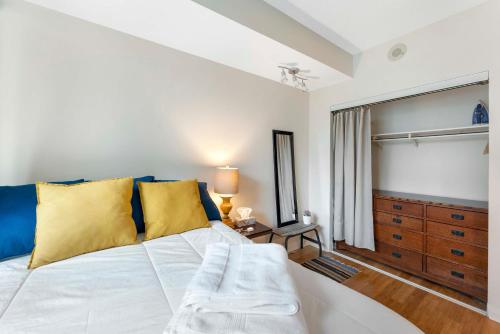 a bedroom with a large white bed with yellow pillows at Luxury 1-Bedroom Condo in Yorkville, Downtown Toronto in Toronto