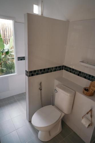 a white toilet in a bathroom with a window at TALI BOUTIQUE Hotel in Ao Nang Beach
