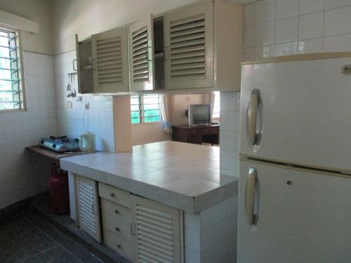 a kitchen with a white refrigerator and a counter at Indiana Beach Apartments in Bamburi
