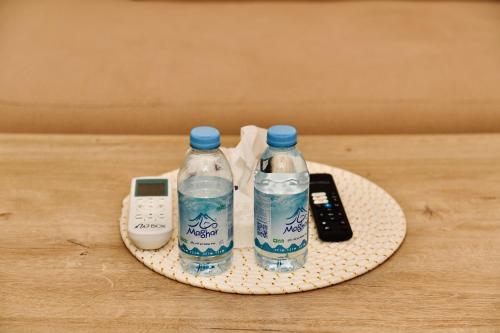 two bottles of water and a remote control on a coaster at Four Stays Khobar in Al Khobar