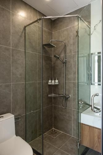 a bathroom with a shower with a toilet and a sink at RAINBOW Motel 3 in Phú Quốc