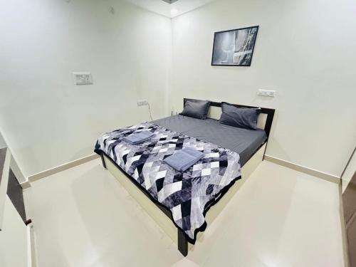 a bedroom with a bed in a white room at 1 BHK Near AIG Hospital Sai Castle Serviced Apartment in Kondapur