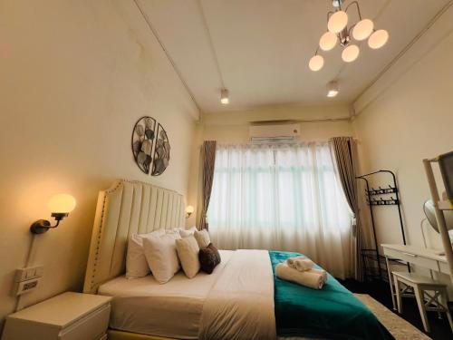 une chambre avec un grand lit avec une fenêtre dans l'établissement Bangrak house 200 meters near BTS SaphanTaksin in city, à Chinatown