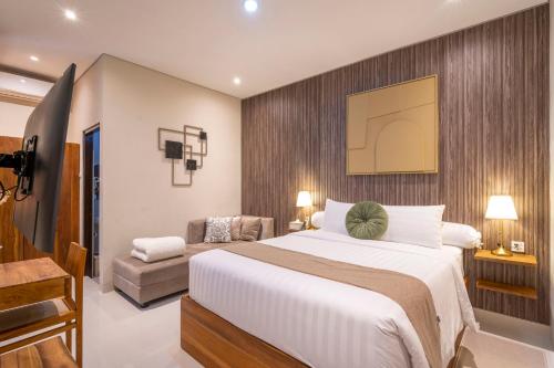 ein Schlafzimmer mit einem großen Bett und einer Couch in der Unterkunft Villa Siji Sanggrahan Private Pool in Kejayan