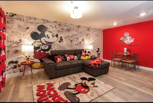 a living room with a mickey mouse wall mural at Mickey's Hideaway Condo Near Disney in Orlando