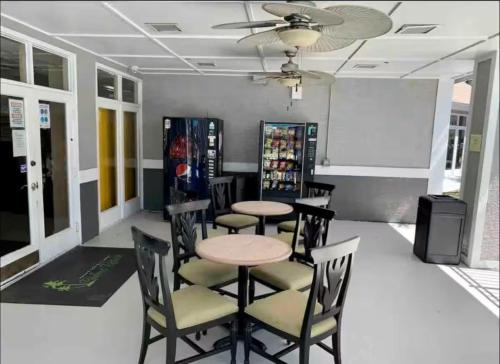 a dining room with tables and chairs and a whiteboard at Mickey's Hideaway Condo Near Disney in Orlando