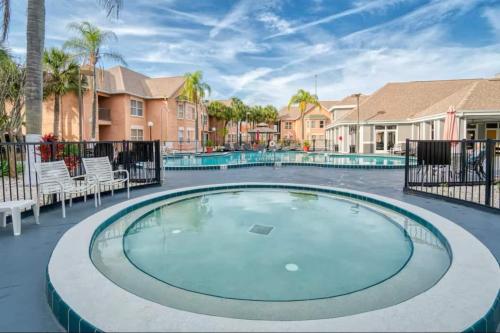 a hot tub in a courtyard with chairs and houses at Mickey's Hideaway Condo Near Disney in Orlando