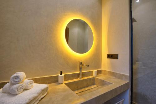 a bathroom with a sink with a mirror and towels at Villa Marrakech in Marrakesh